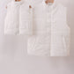 Two white puffer vests hanging on wooden hangers against a white background