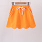 Orange scallop hem bow skort